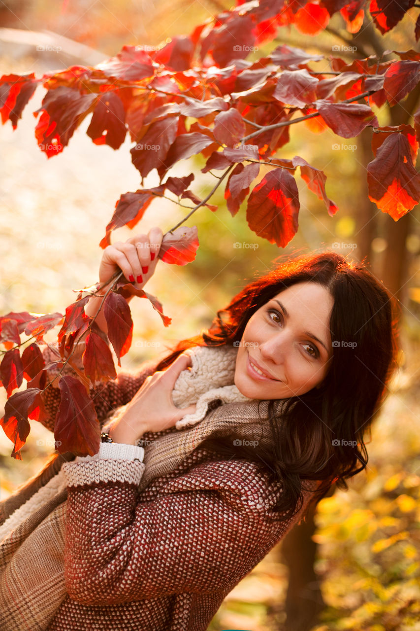 Close-up of a woman holding tree branch