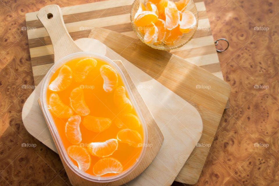 Delicious orange jelly with tangerine slices in a container and jelly worms.