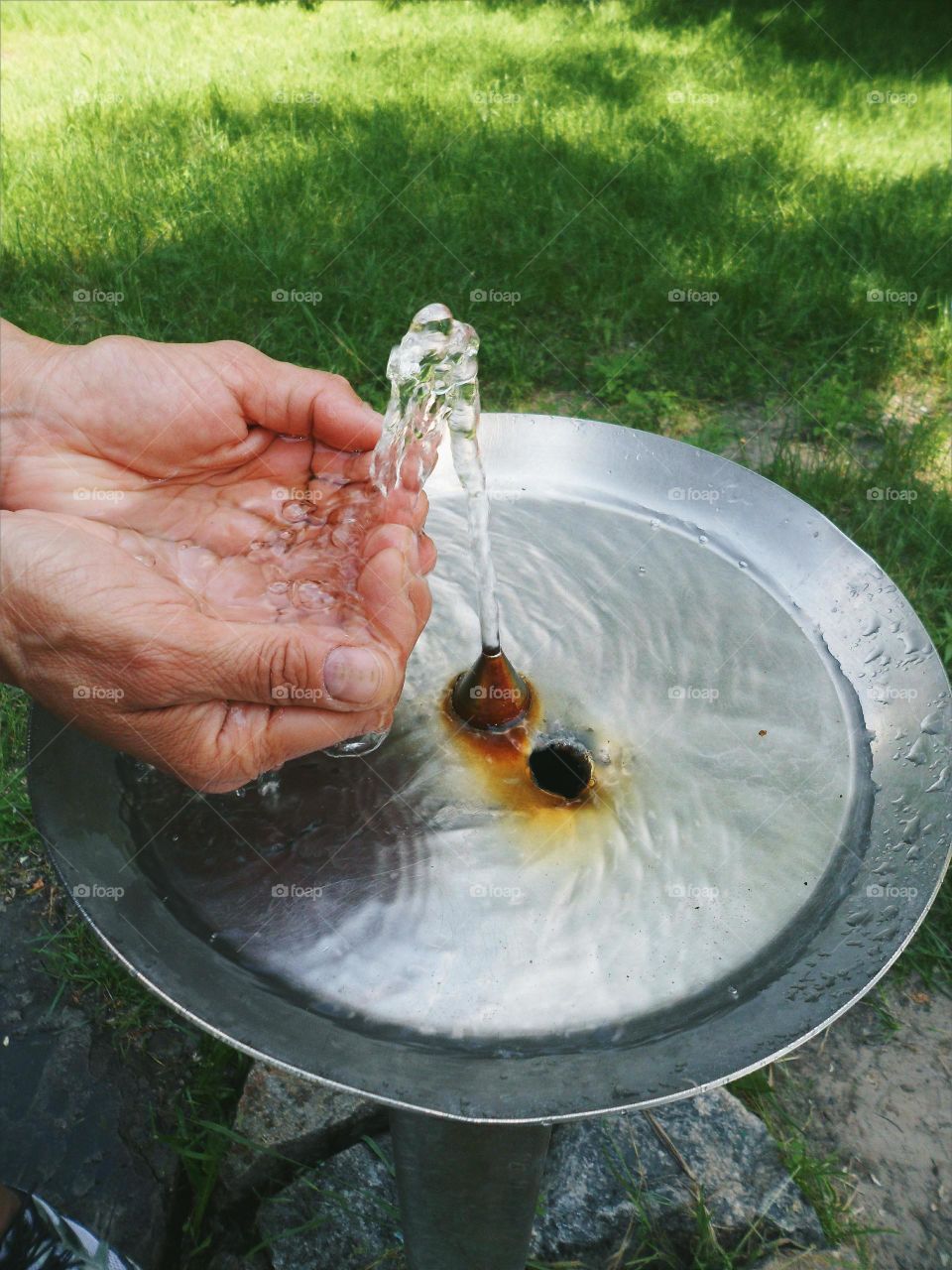 It is typed into the hands of the water fountain