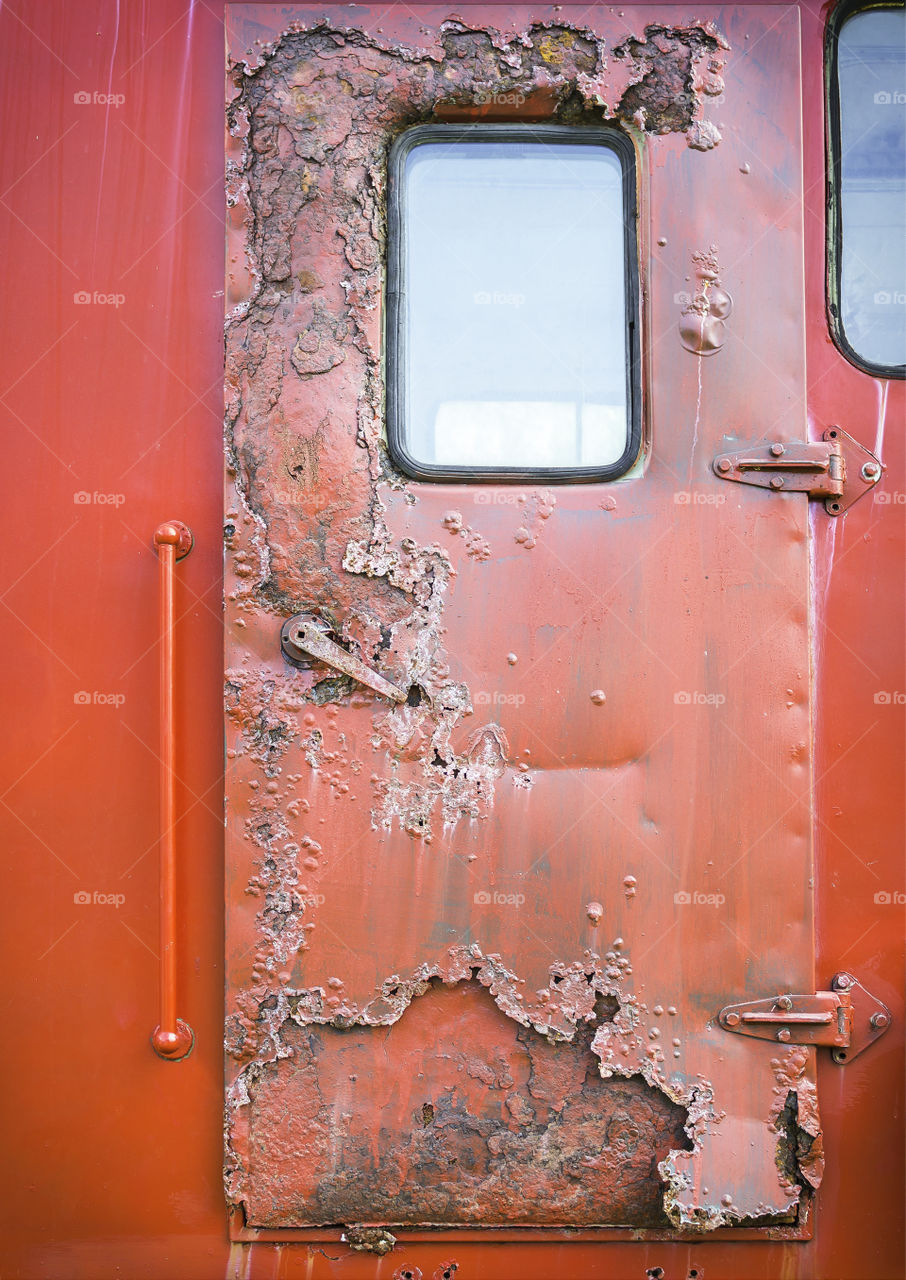 Old red car door and rusty texture background
