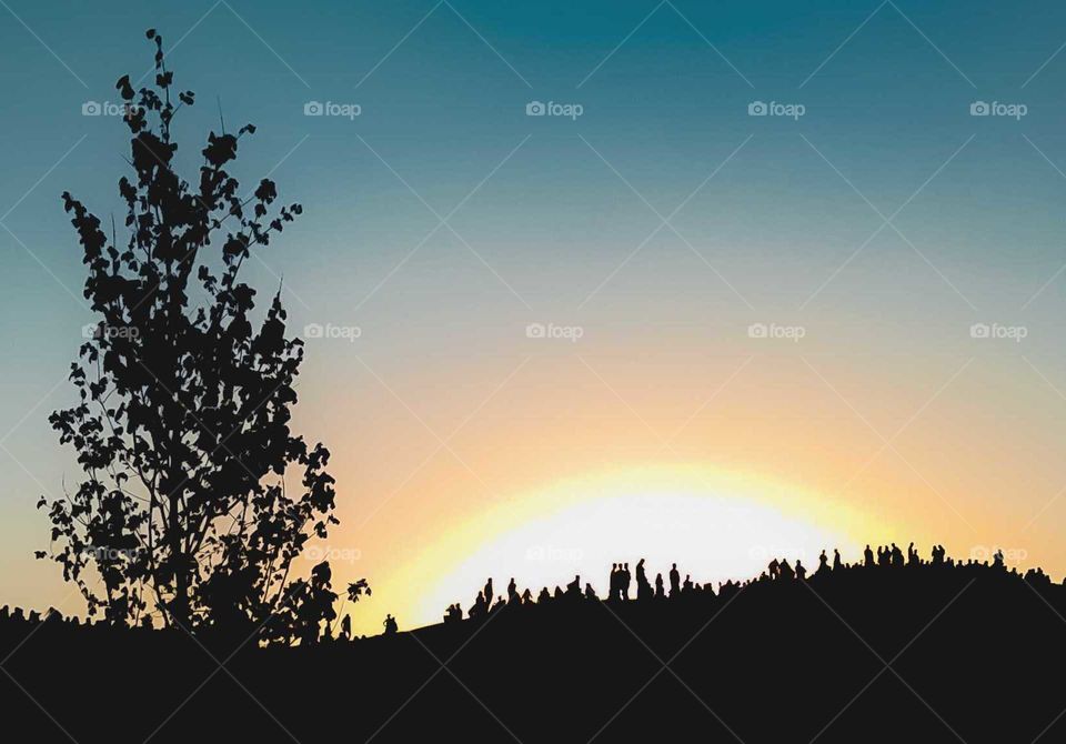 Silhouette of people on the hill at dawn
