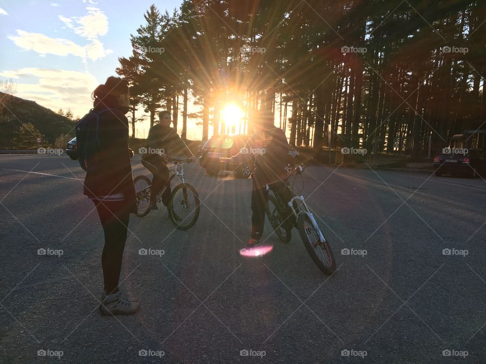 Boys riding bikes at sunset