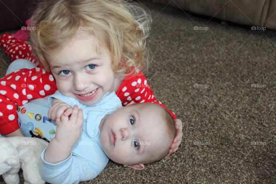 Little girl playing with cute baby