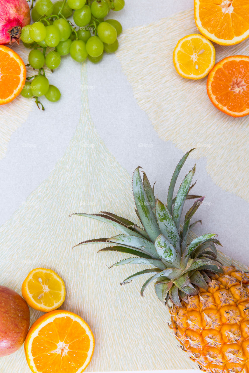 Flat lay with whole and sliced fresh fruit on textured background. Yellow and orange warm colors for hot summer days.