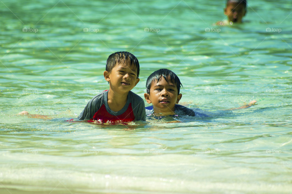 Two Asian boy playing in sea water