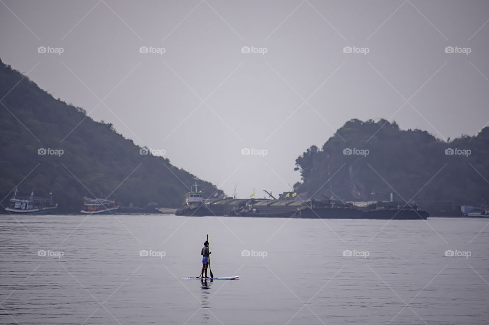 Tourists on surf boards in the sea at Prachuap Bay in Thailand.