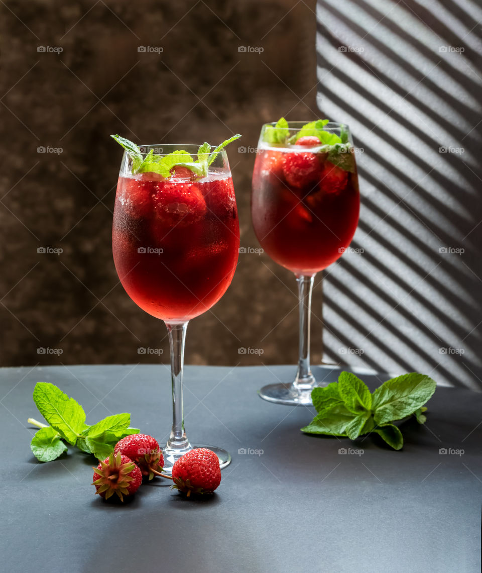Fresh and red cocktails made with strawberries, mint and some drink.