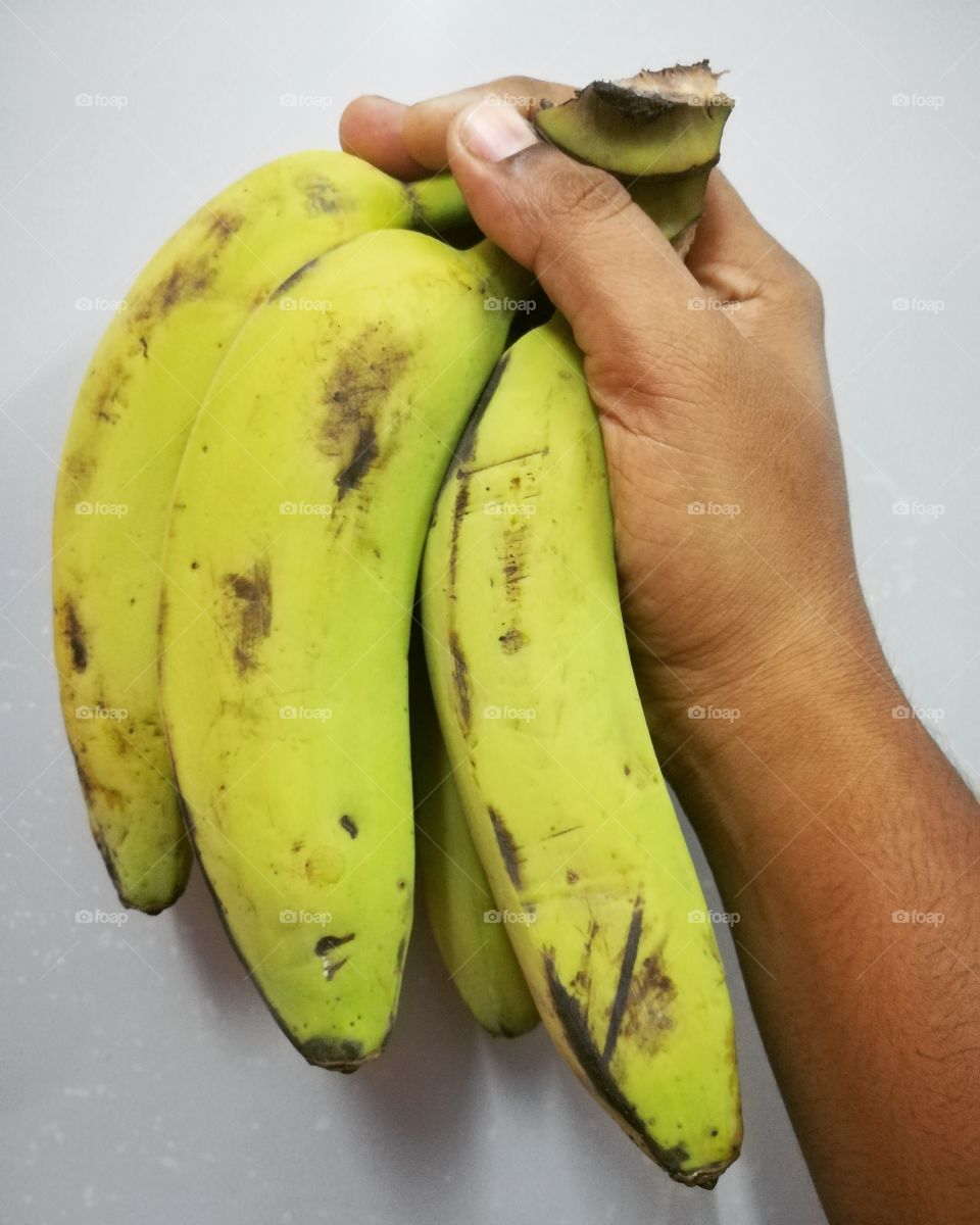 Hand holding bunch of banana