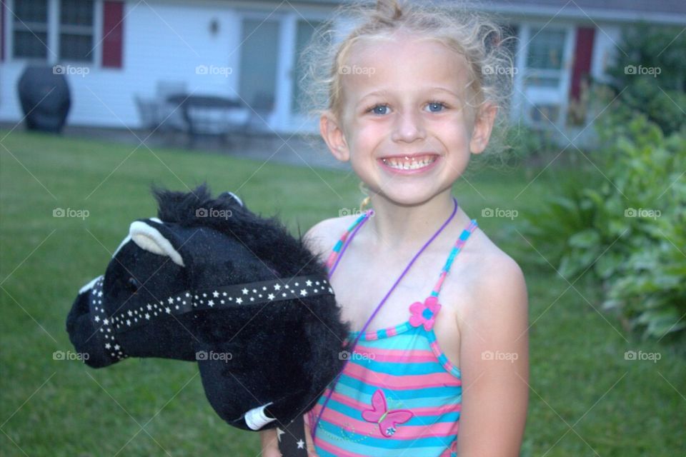 Close-up of a girl playing with horse stick