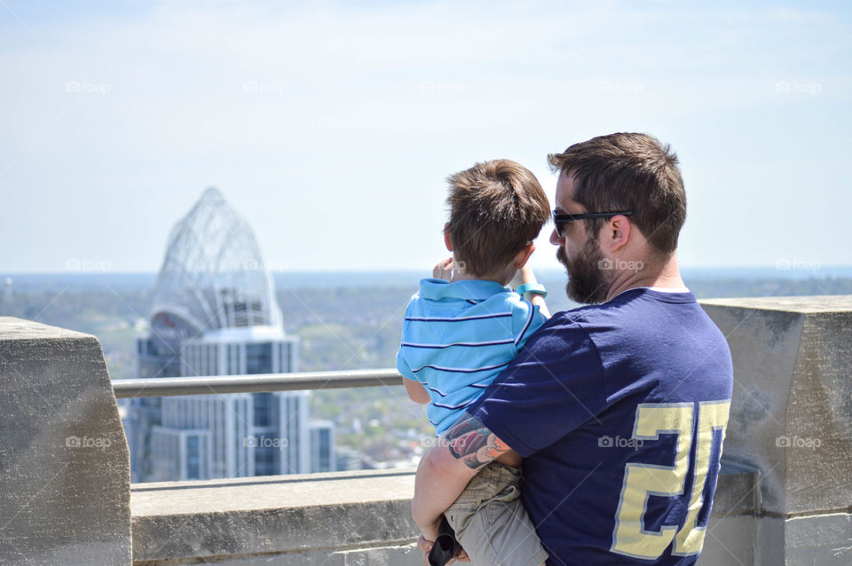 Father and son looking out over the Cincinnati skyline