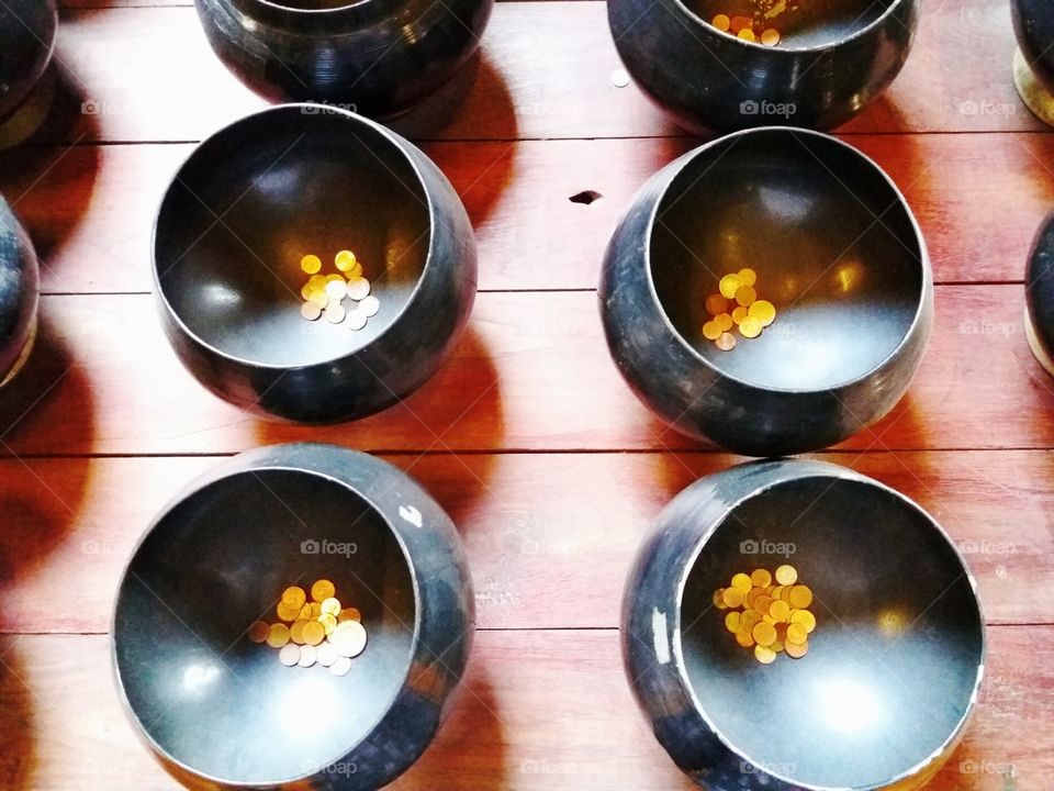 Coins for donation in a black bowl
