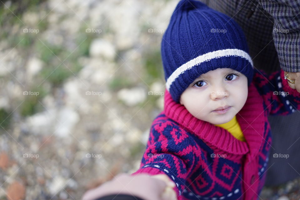 Elevated view of cute boy in hat looking at camera