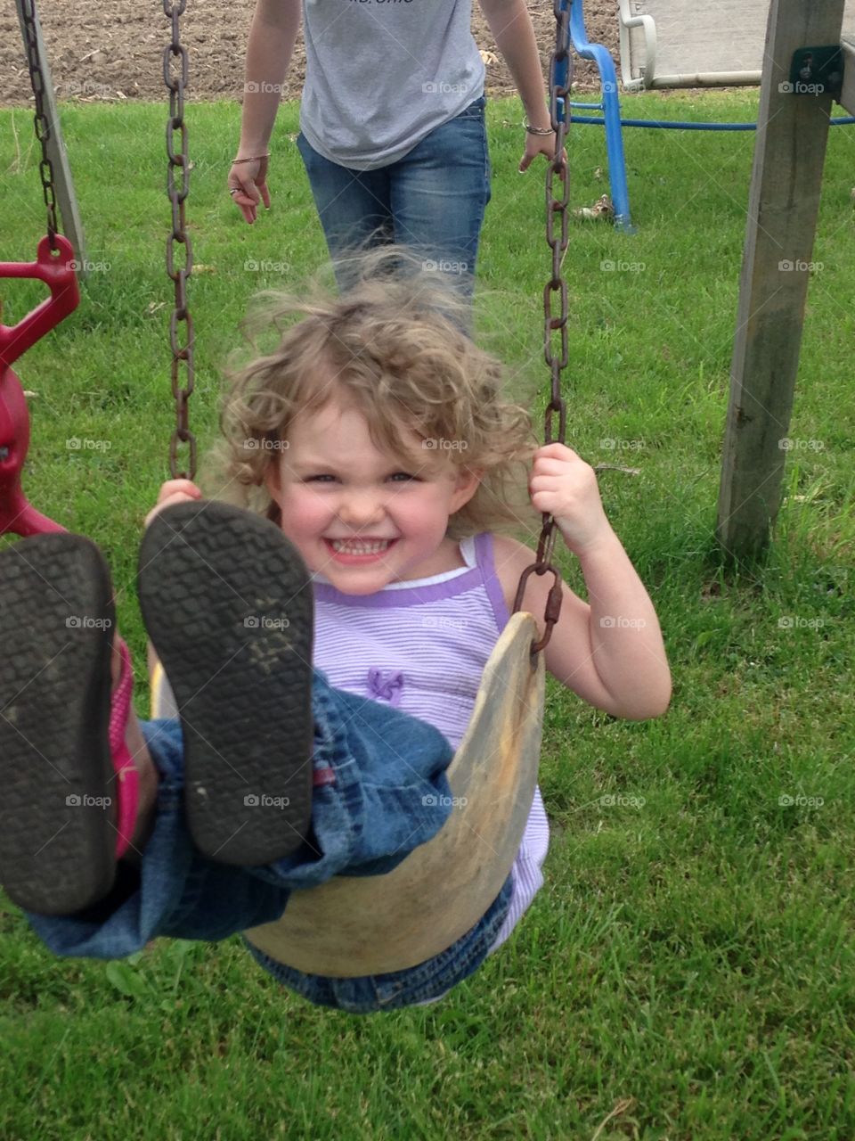 Swinging on playground. Having a great day playing, enjoying the outdoors, swinging on a swing set.