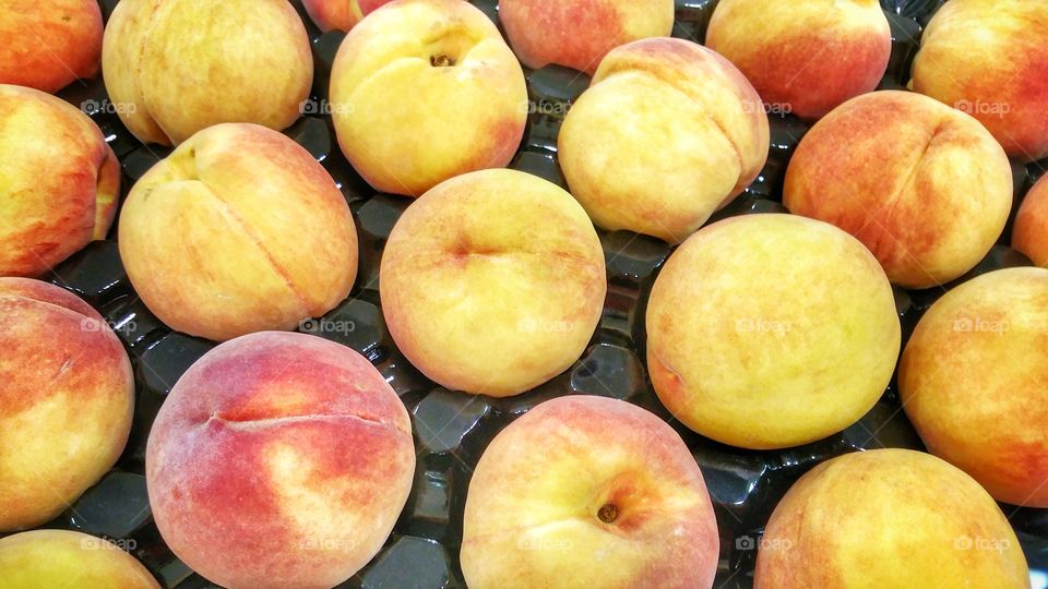 Peaches in season. Packaged and presented in a supermarket department.