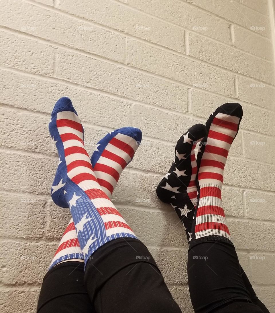 Popfizzy American flag socks on white brick background.