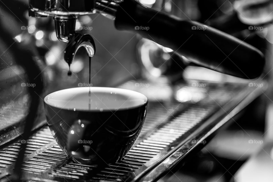 Cup of cappuccino in the machine at the cafe