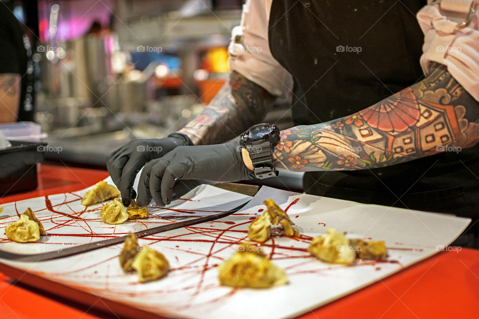 Chef placing dumplings on a dish at a restaurant