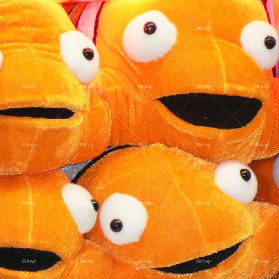 Googly fish eyes . Stuffed goldfish toys are prizes waiting to be won at the fair