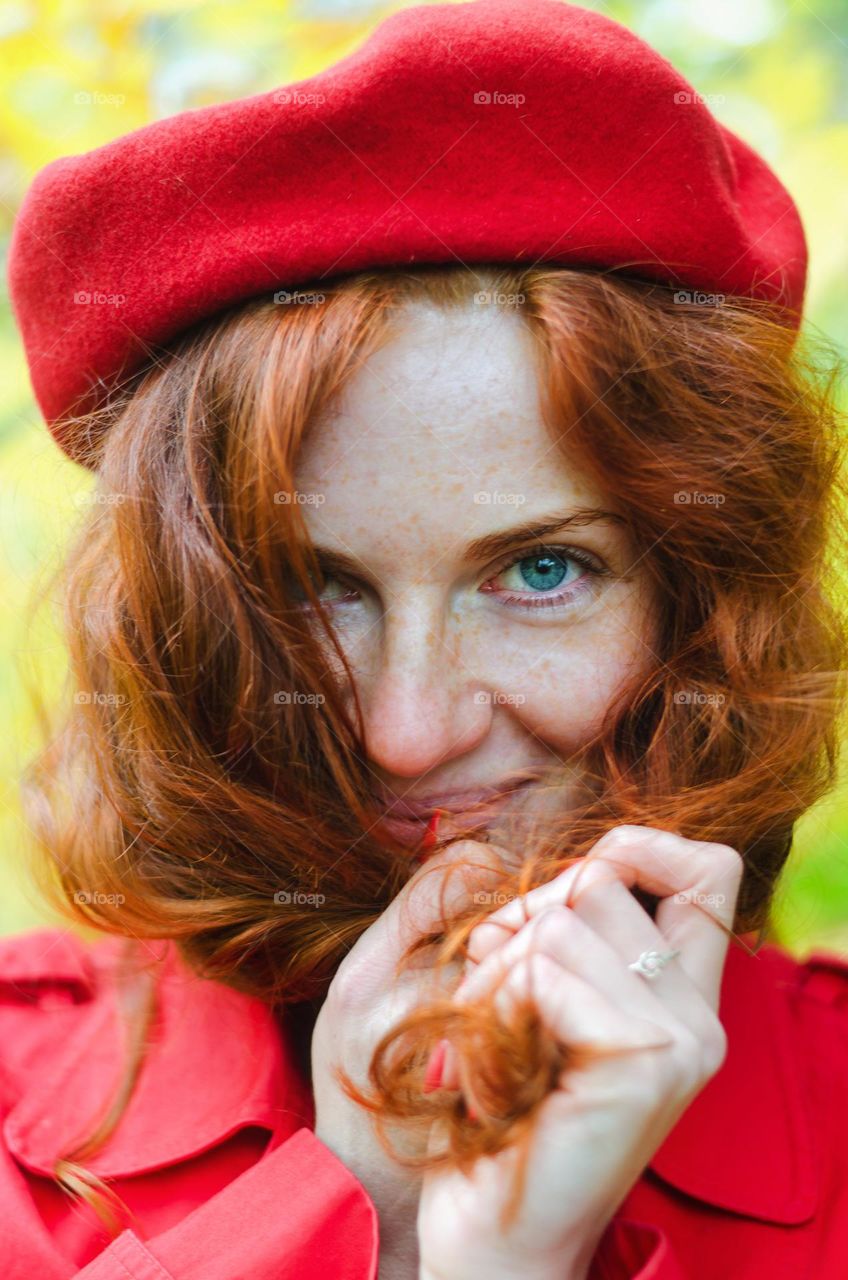 Close up portrait of young, beautiful redhead curly girl, woman in red beret in autumn Park. Happy lifestyle