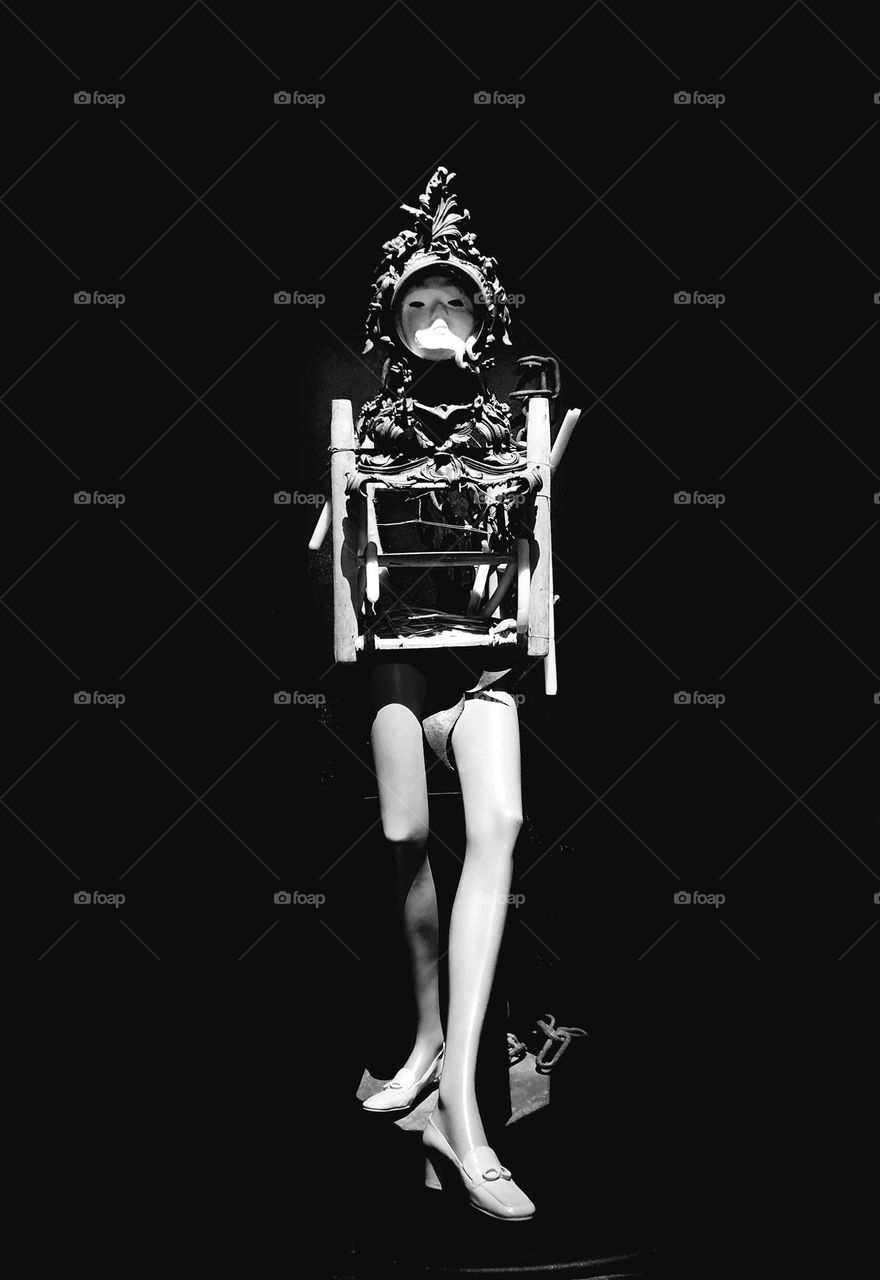 Black and white shot of a Salvador Dali's work of art consisting of a mannequin wearing a vintage carved iron helmet exposed in his museum theater in Figueras, Spain