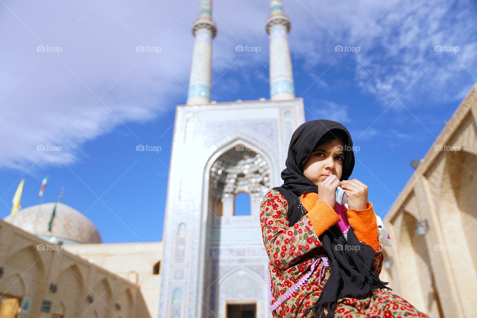Cute girl sitting in front of mosque