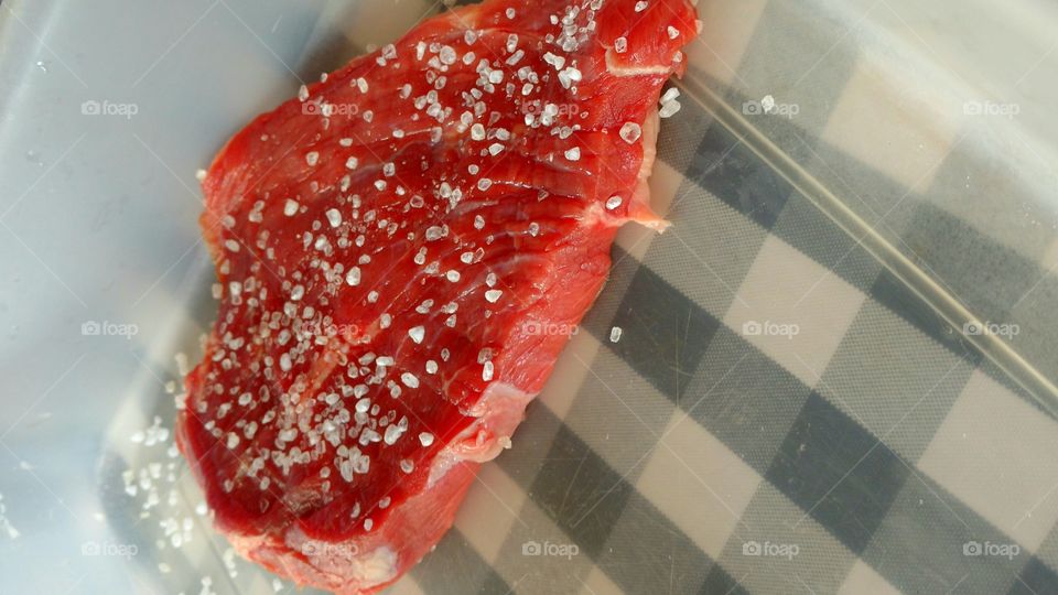 Manta de carne crua com sal grosso, pra churrasco.