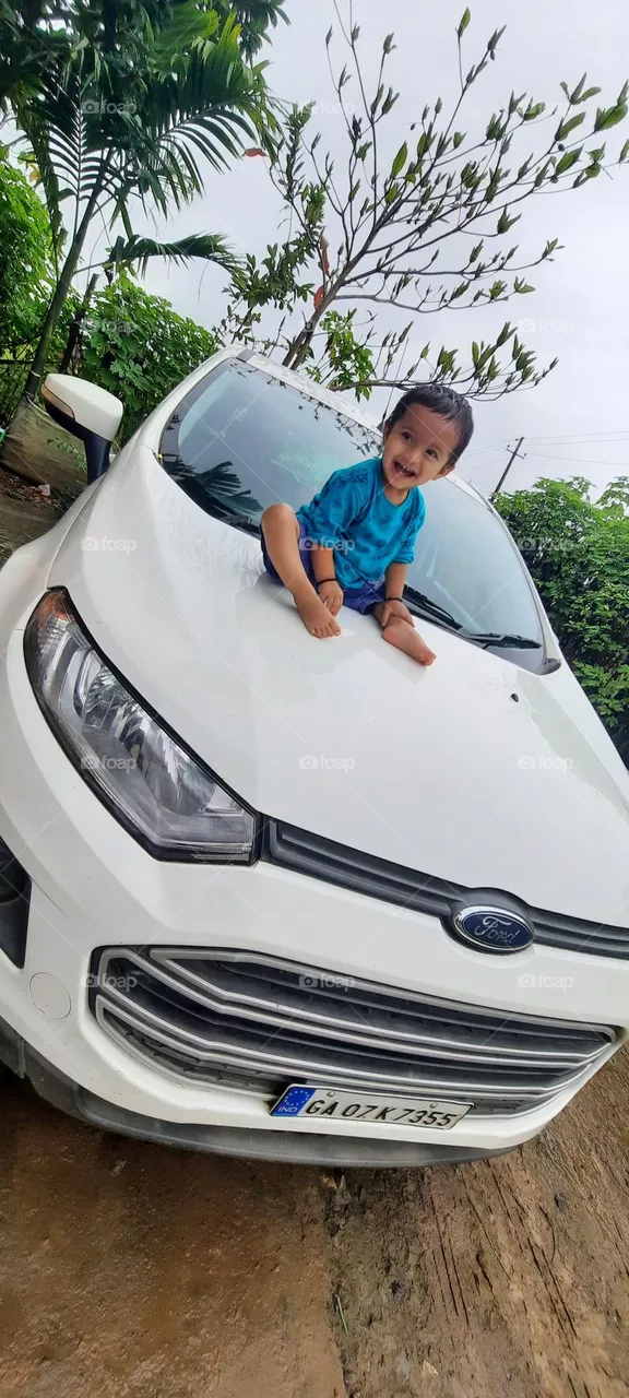 baby sit on the bonnet of the car