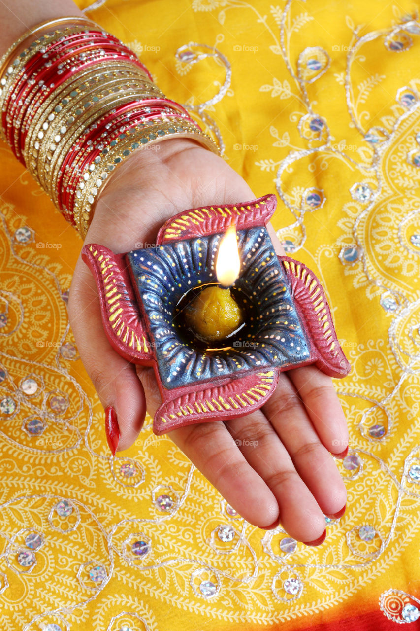 Indian festival Diwali diya oil lamp on female hand