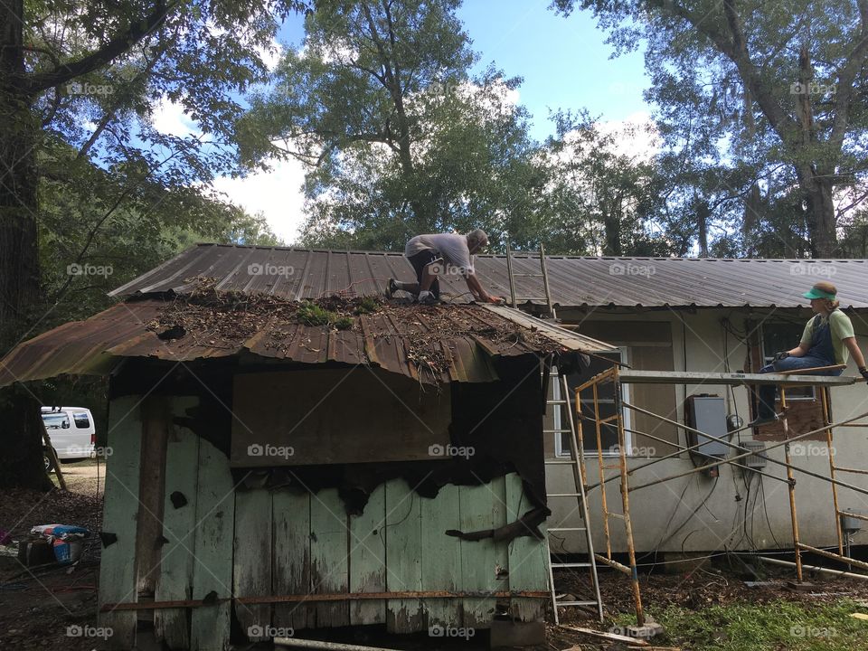 Two high schoolers work together to repair a home damaged by Hurricane Katrina. July 2016. 