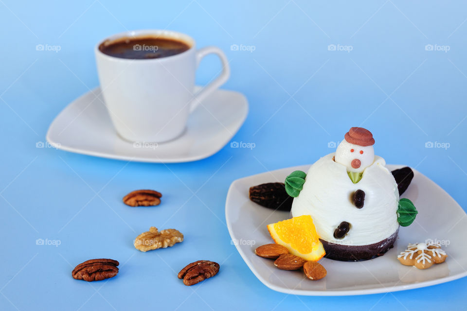Ice cream background in the shape of two edible snowmen on white plates close up. Top view. Funny food idea for kids.