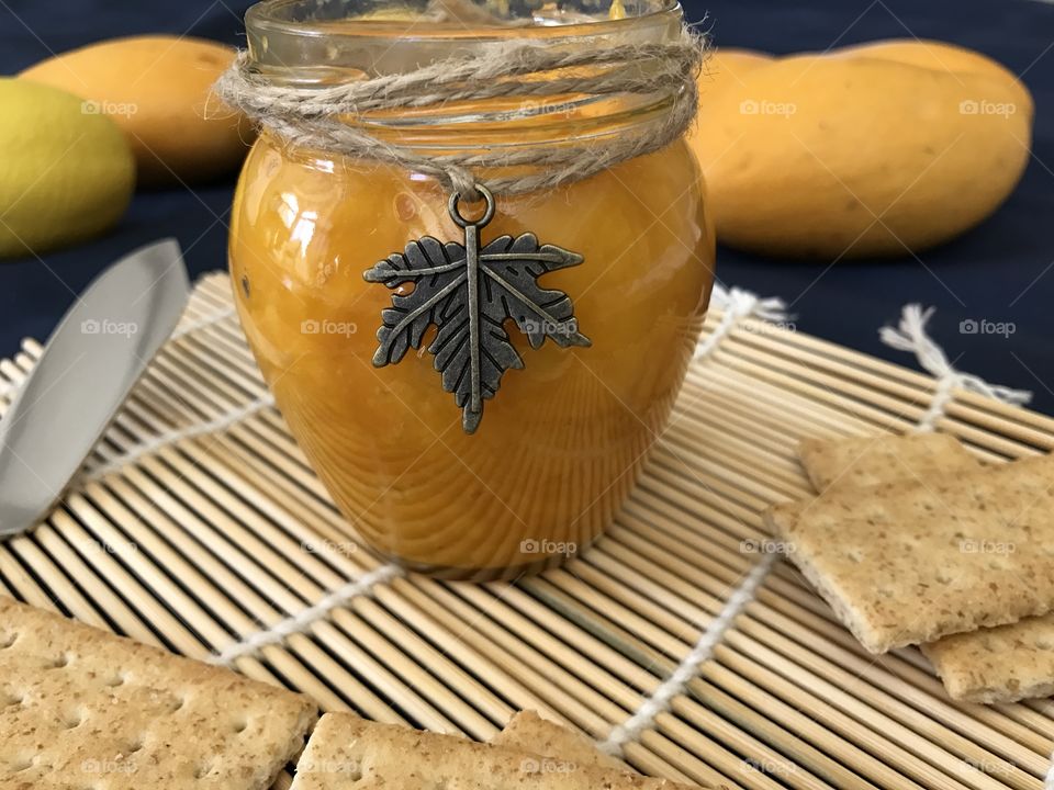 Mango jam with crackers on bamboo plate mat 