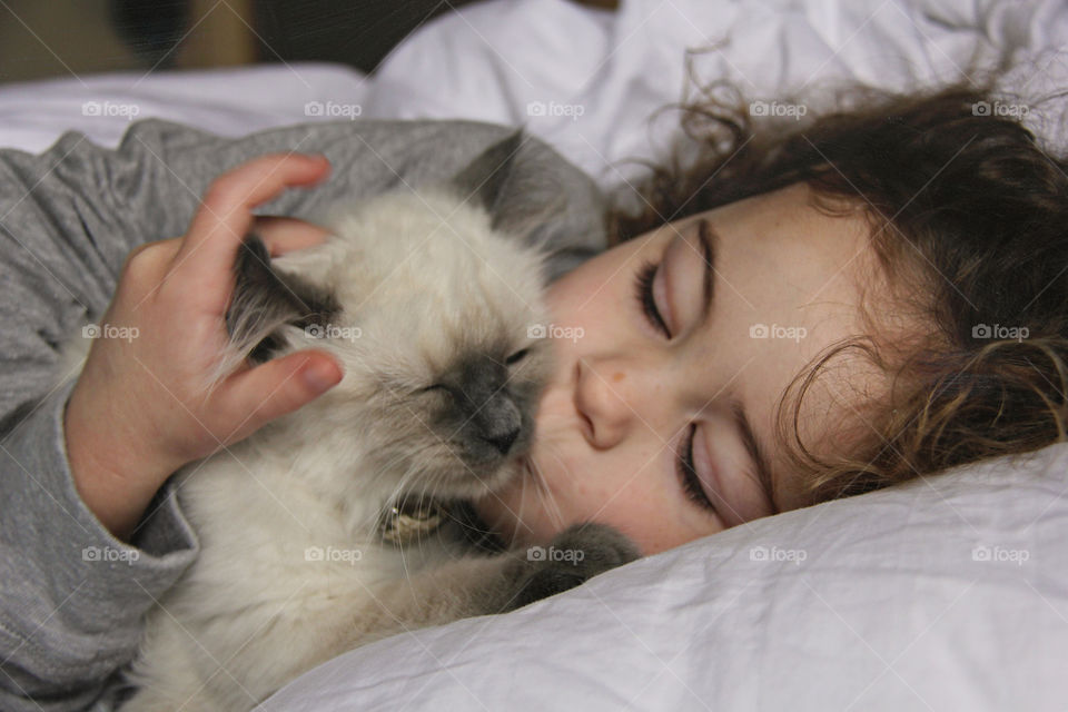 Girl sleeping with her pet cat