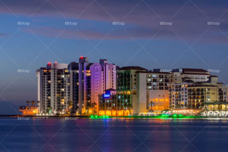 beach skyline of resorts and clubs with colorful lights on the waterfront at blue hour