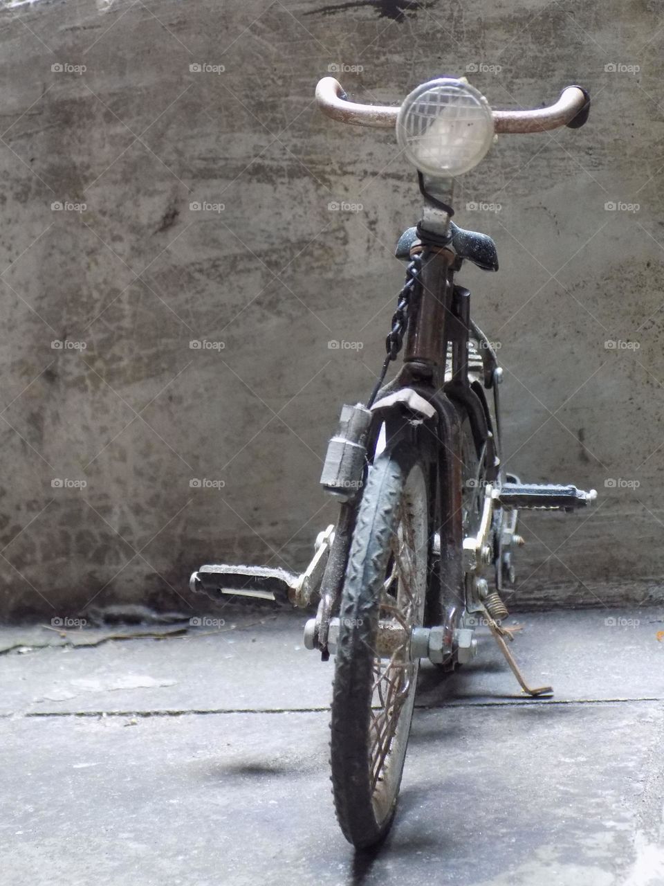 Old, rusty and broken toy bicycle