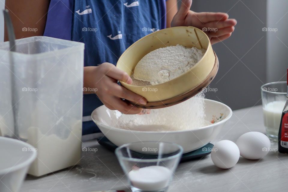 Child is sifting flour