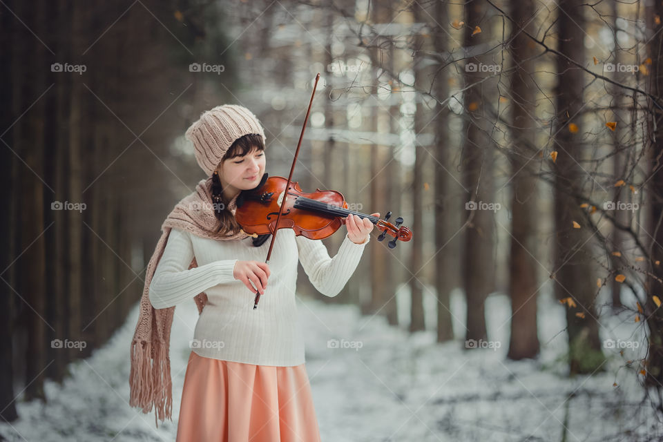 Teenage girl portrait with violin in winter park