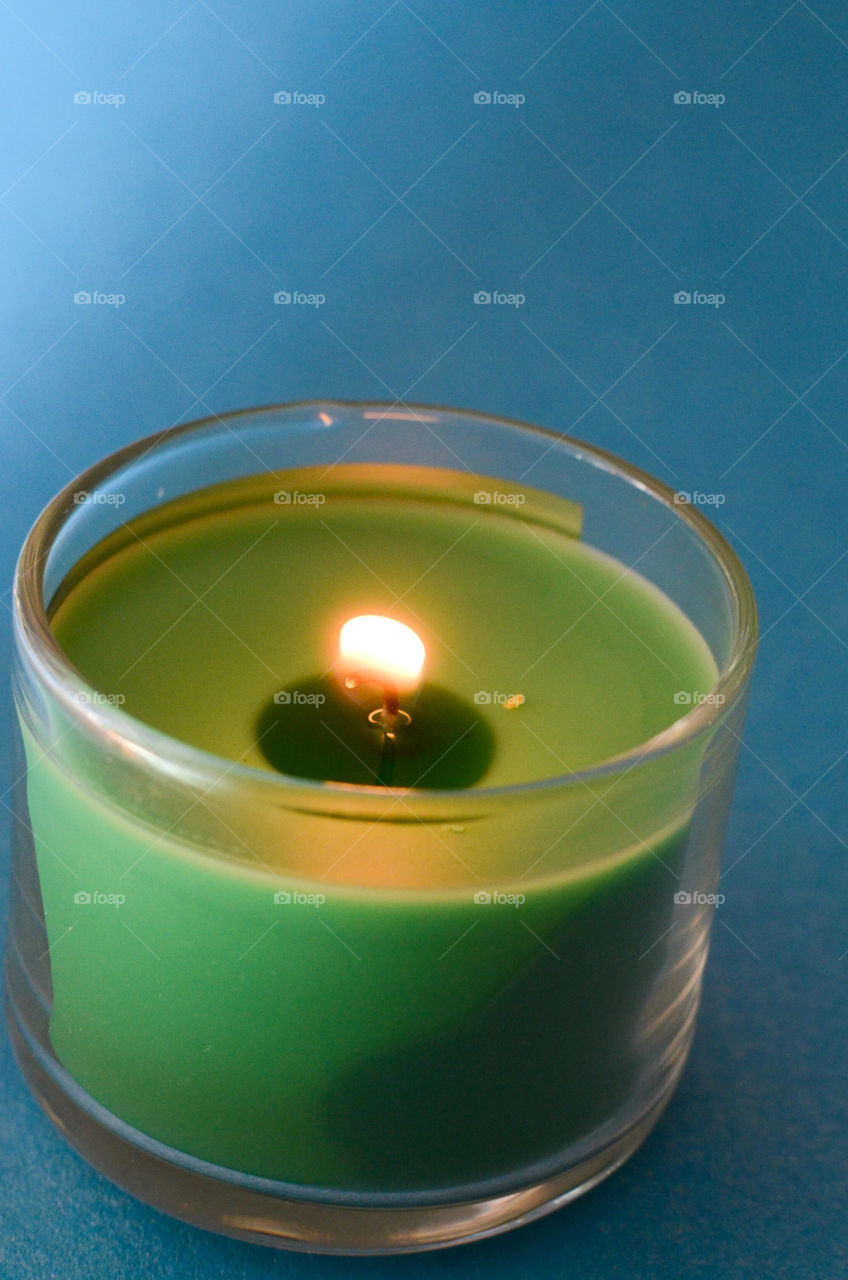 green candle on blue background