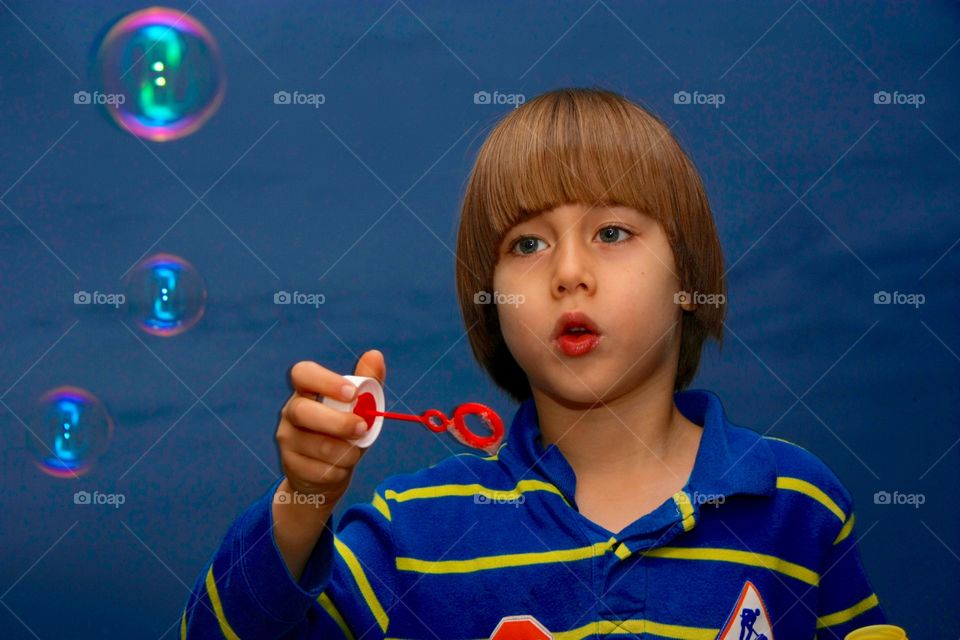 Little Kid Playing With Soap Bubbles. Little Kid Playing With Soap Bubbles