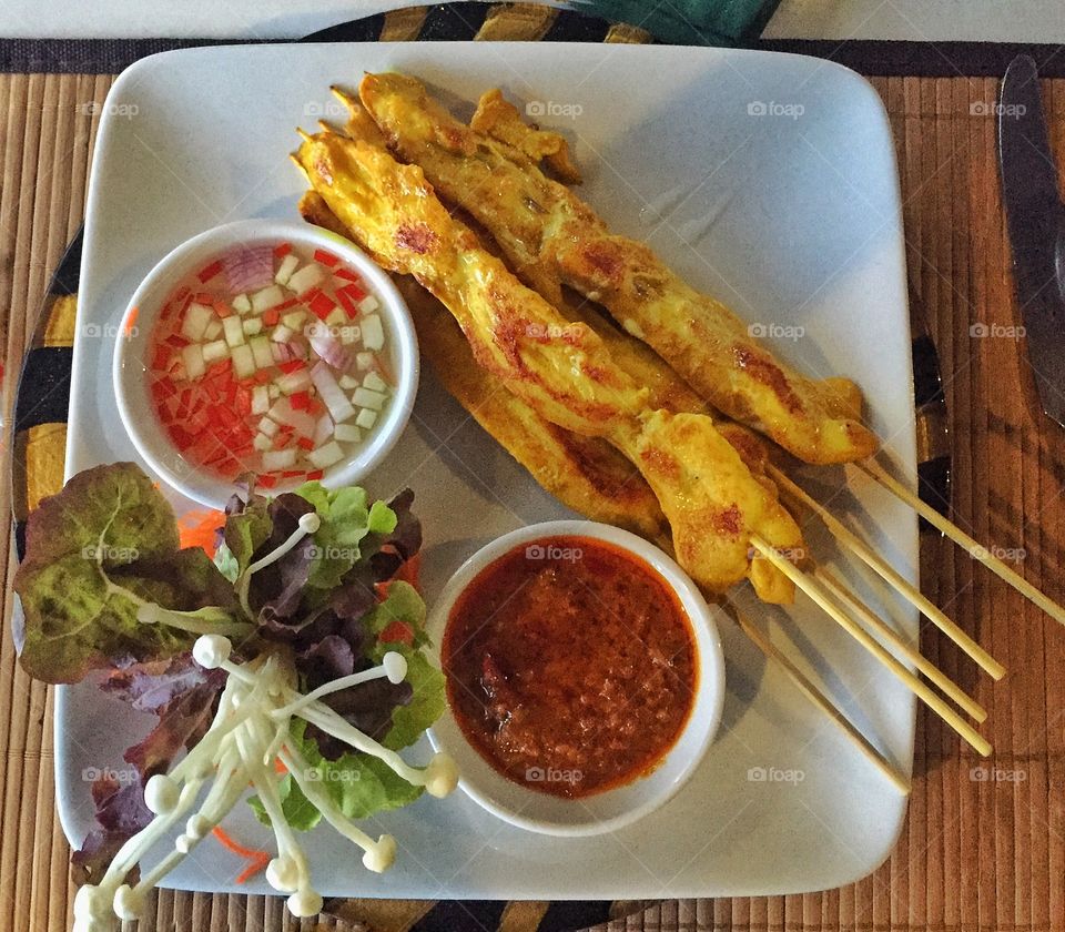 Chicken satay on white plate