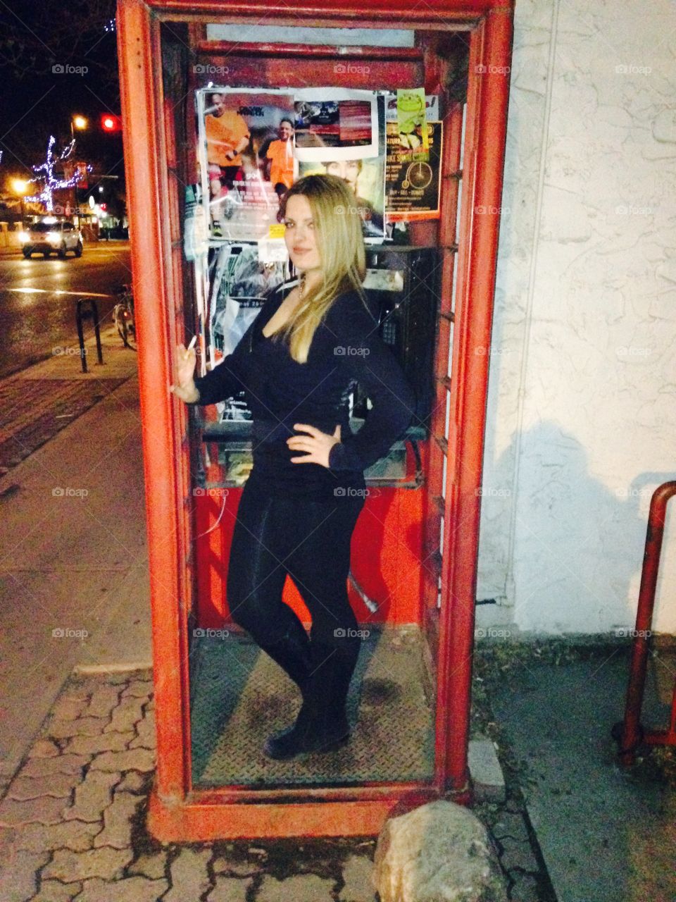 Woman standing in telephone boot