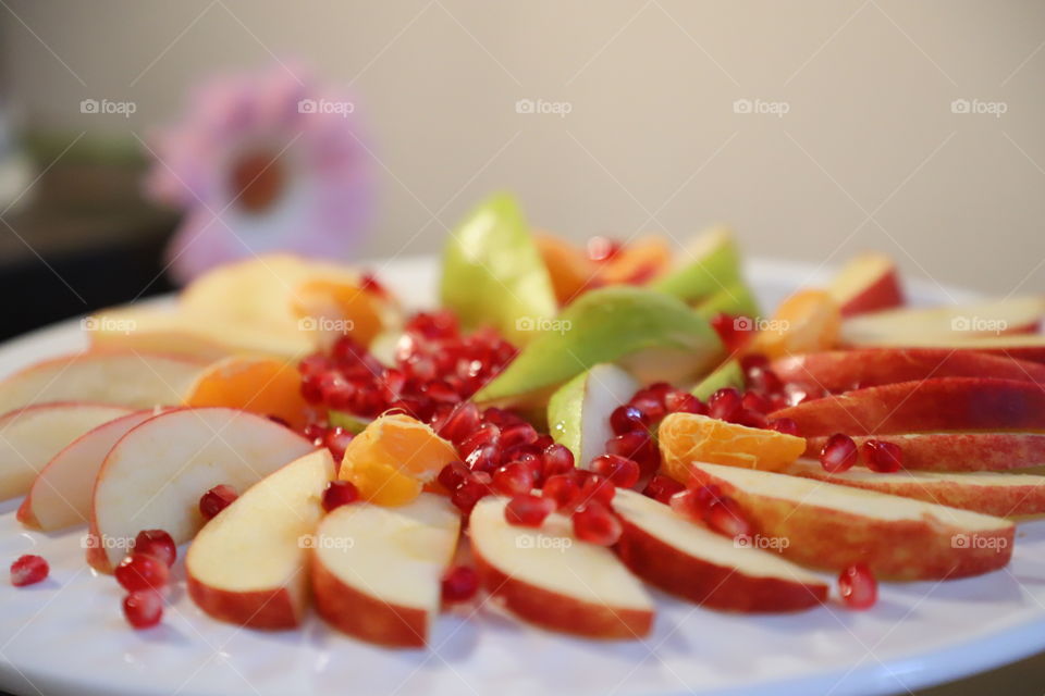 Fresh cut fruits on white platter 