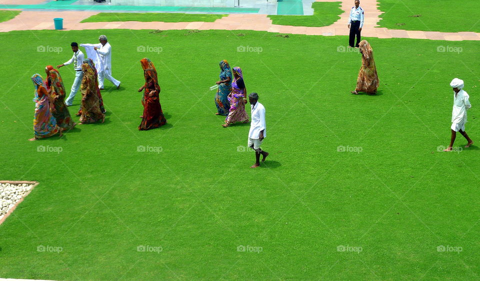 indian people walking on a lawn