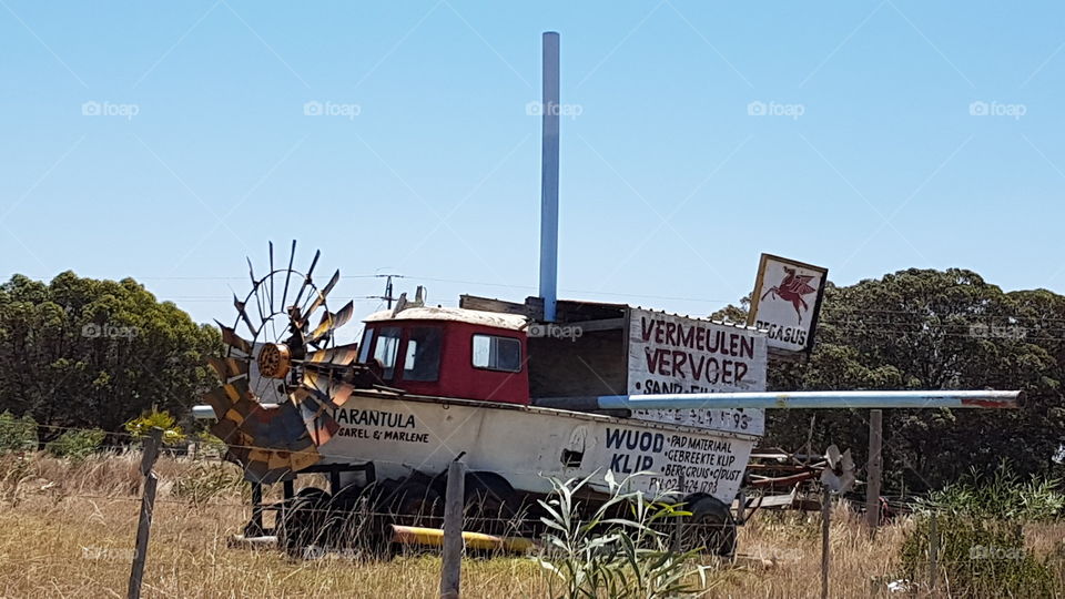 A boat miles from the sea with a windmill in front. South Africa