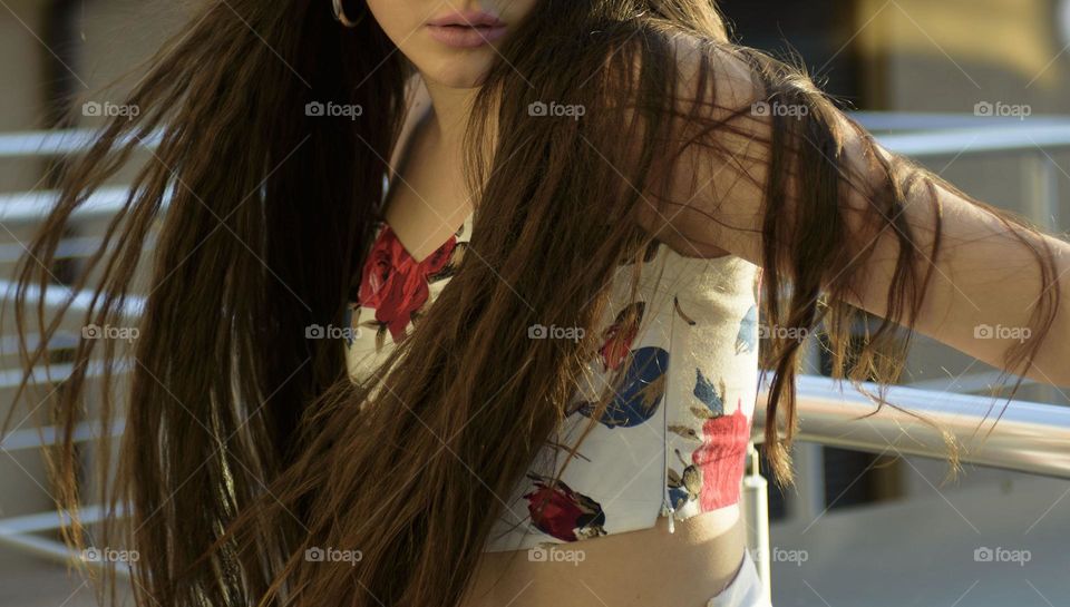 A girl with long beautiful hair on a summer day in the rays of the setting sun.