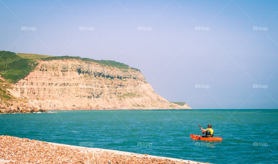 A kayaker paddles along the shore at rock-a-nor in Hastings