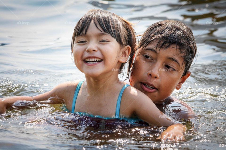 Children are swimming in the lake in summer