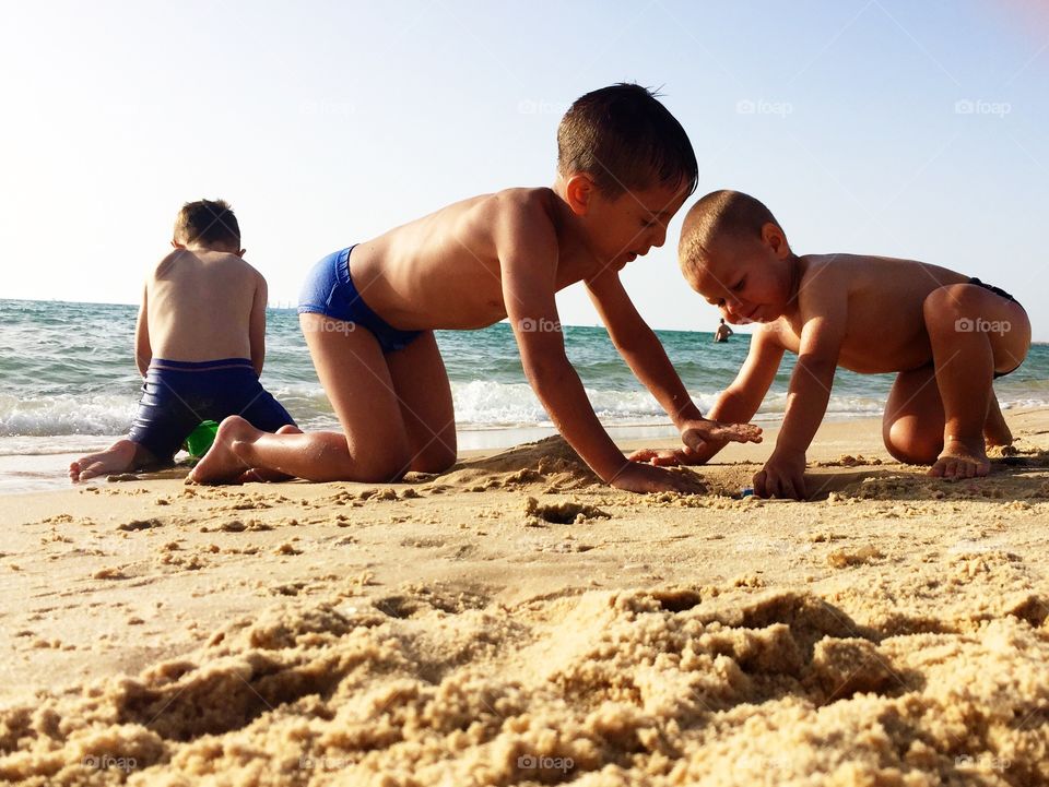 Children playing at beach with sand