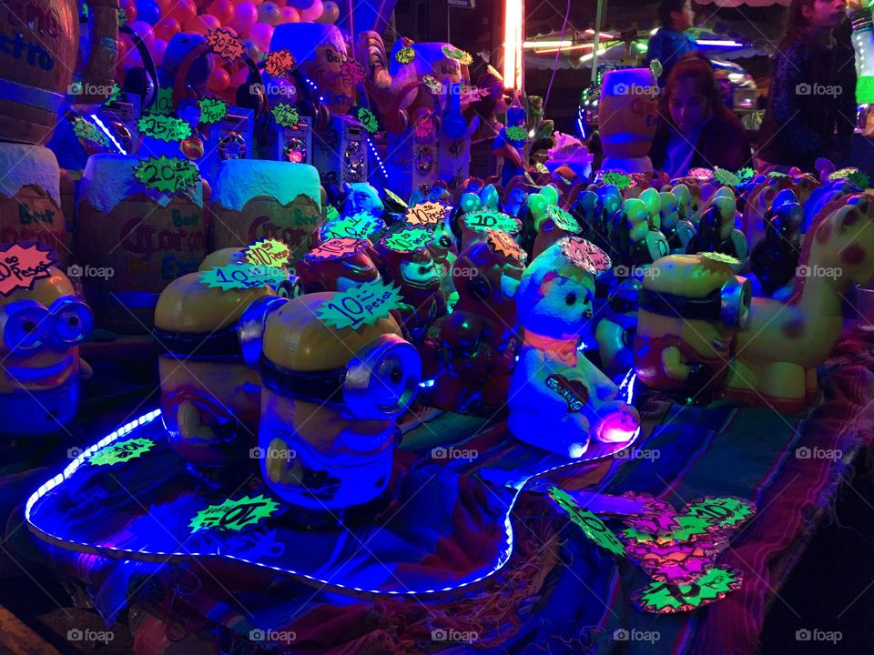 Radical crazy colorful neon lights on ceramic figures sold at a local Fair in Mexico City. Starring minions and their animal friends 🌈