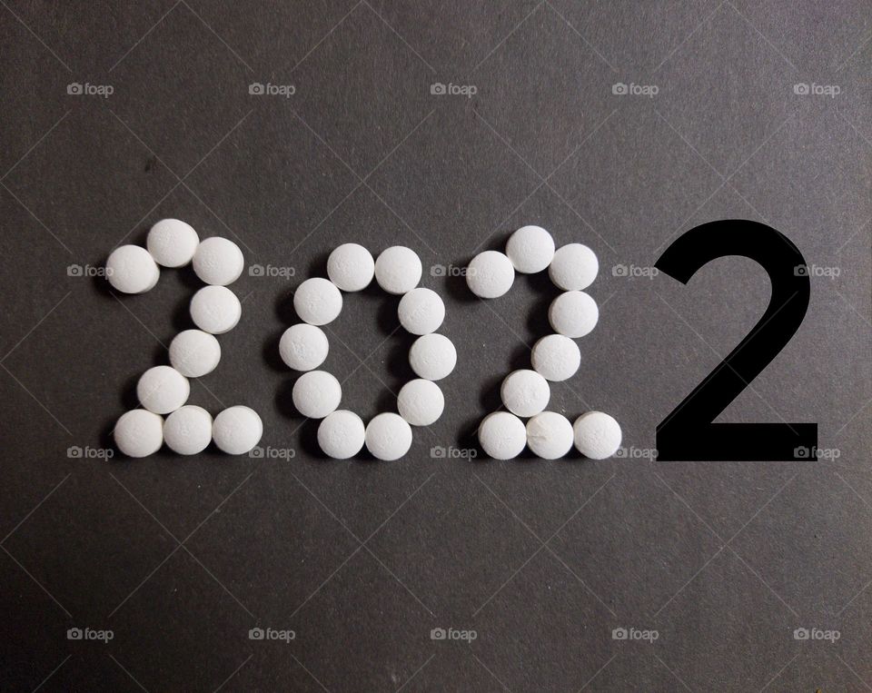 new year 2022 with white colour and last number 2 it's with black colour to distinguish , pills concept , black background