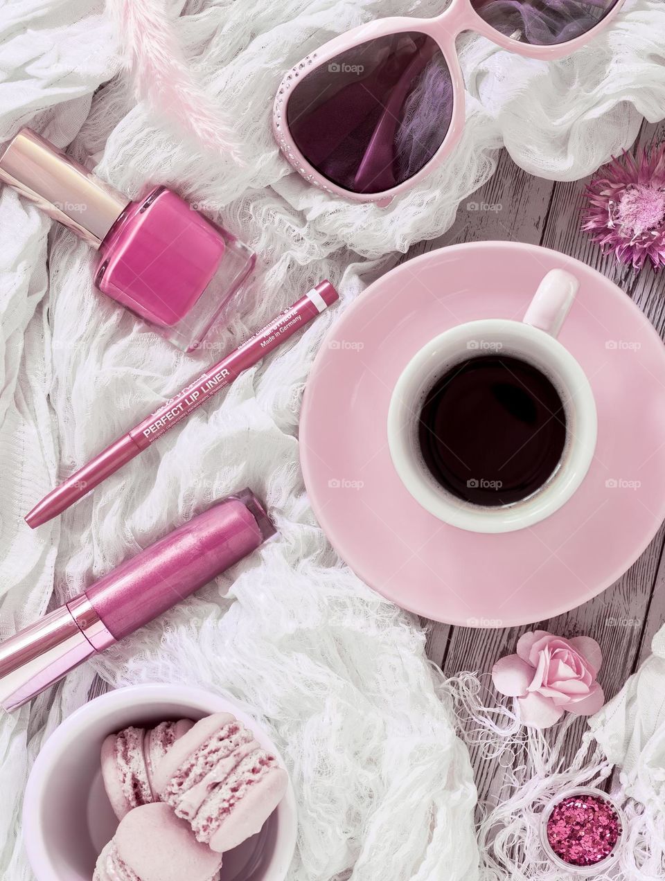 Flat lay with pink cosmetics, macaroons and coffee